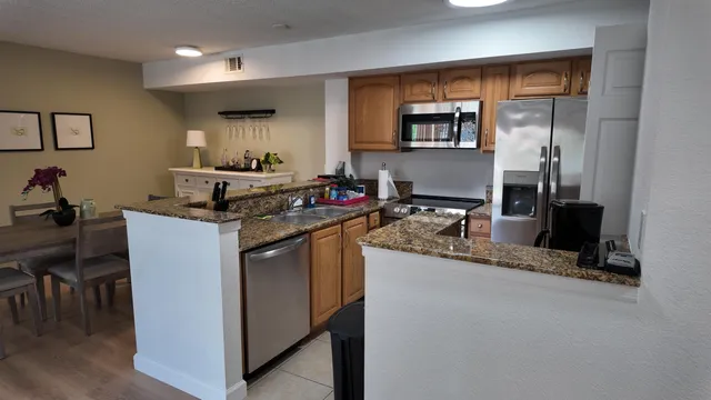 a kitchen with stainless steel appliances granite countertop a sink stove and cabinets