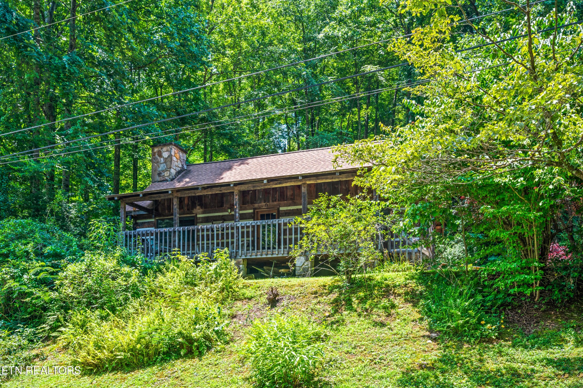 727 Hidden Valley Road Gatlinburg, TN 37738 - Photo 5 of 22 a view of a house with a small yard plants and large tree