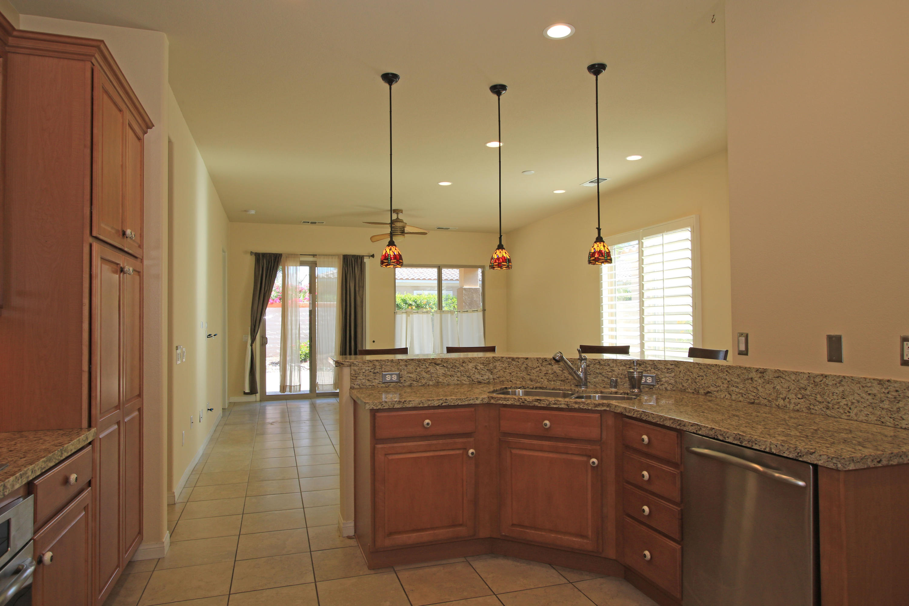 81642 Avenida Bolero Indio, CA 92203 - Photo 12 of 38 a kitchen with a granite countertop sink window and a wooden floor