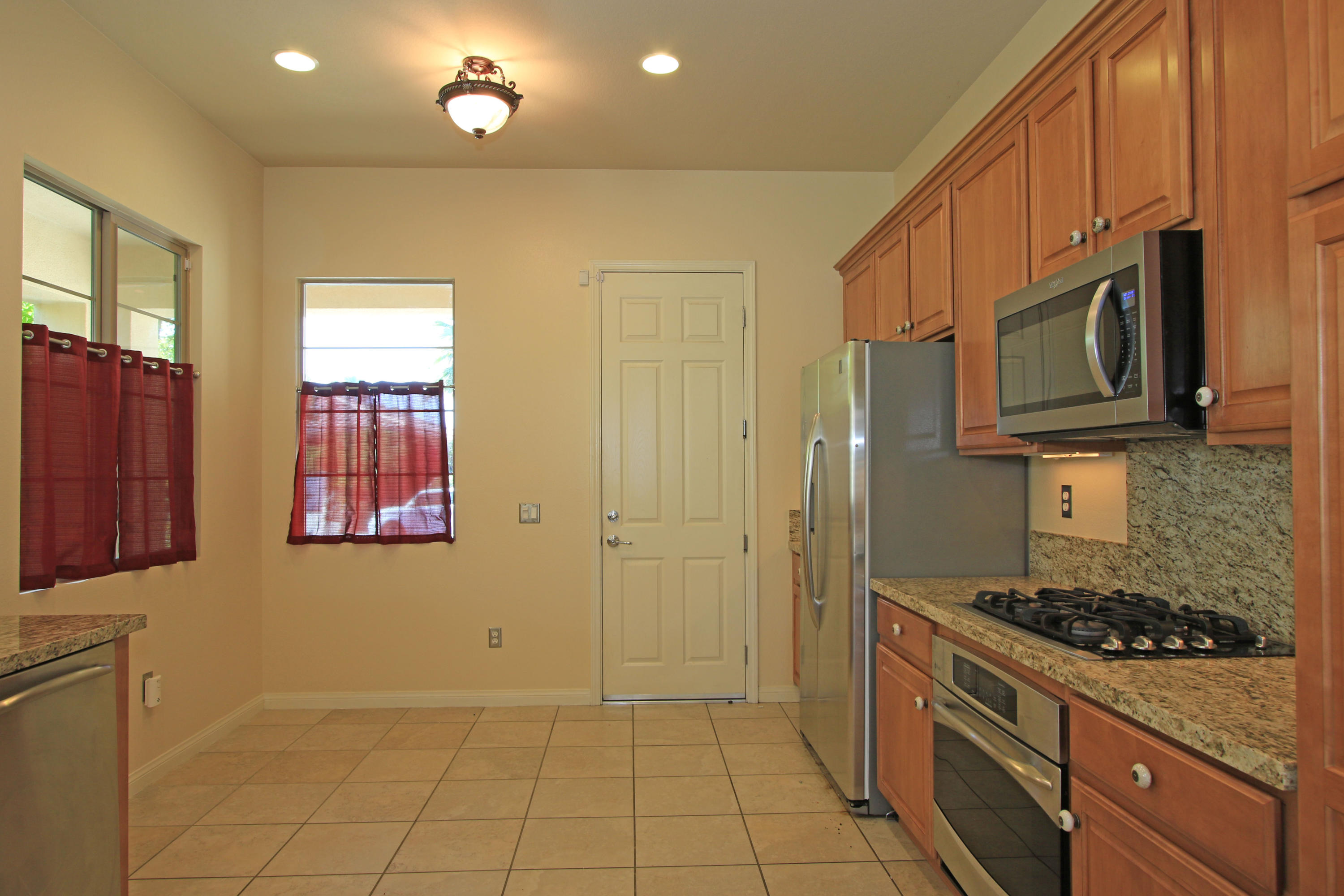 81642 Avenida Bolero Indio, CA 92203 - Photo 13 of 38 a kitchen with stainless steel appliances granite countertop a stove a refrigerator and a microwave