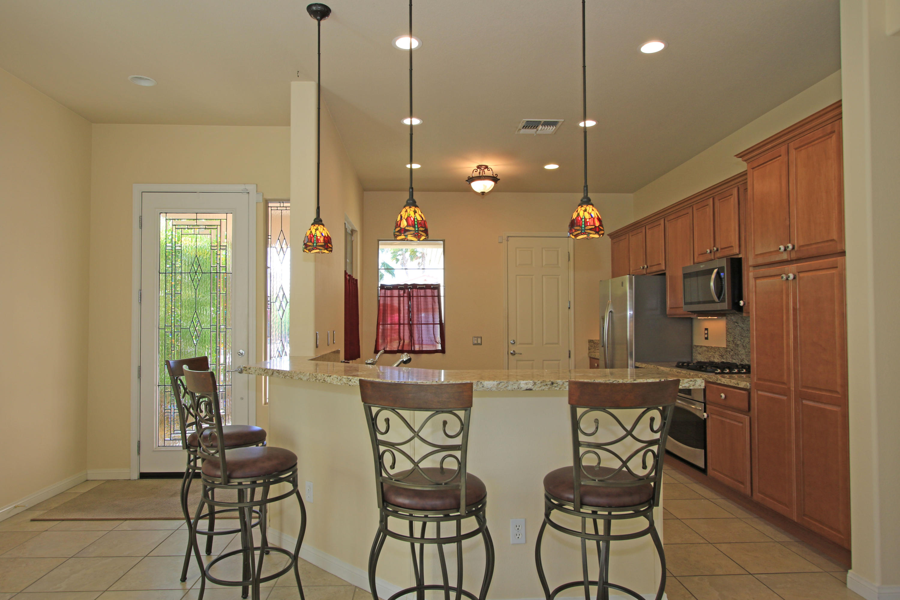81642 Avenida Bolero Indio, CA 92203 - Photo 4 of 38 a kitchen with stainless steel appliances kitchen island granite countertop a sink and cabinets