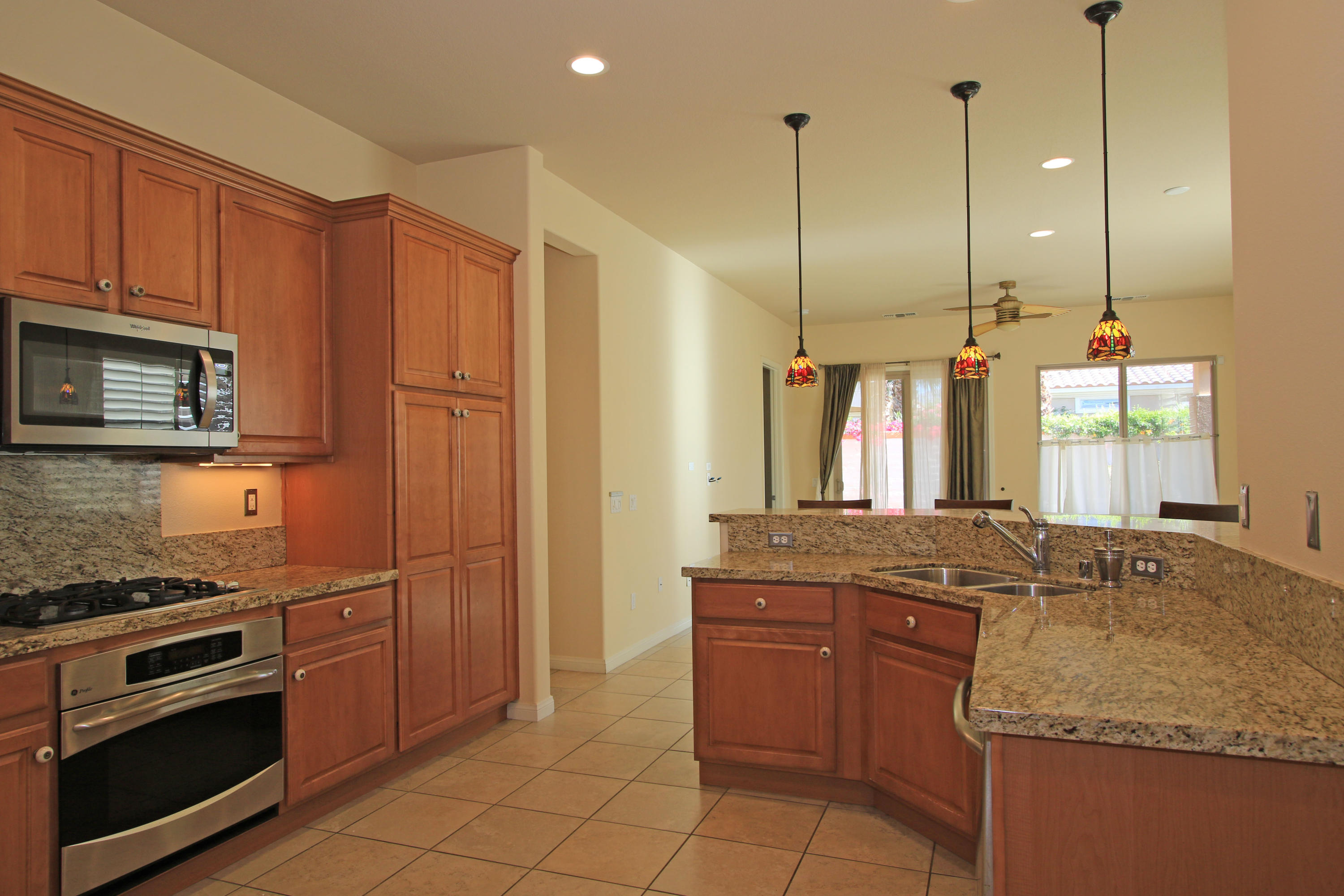 81642 Avenida Bolero Indio, CA 92203 - Photo 10 of 38 a kitchen with stainless steel appliances granite countertop a sink a stove a microwave and island