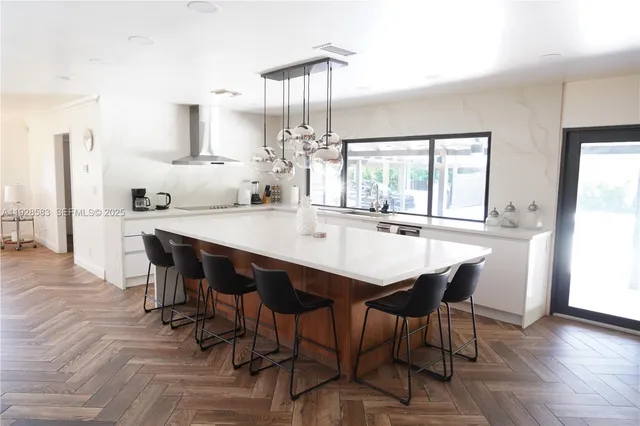 a dining room with furniture a chandelier and wooden floor