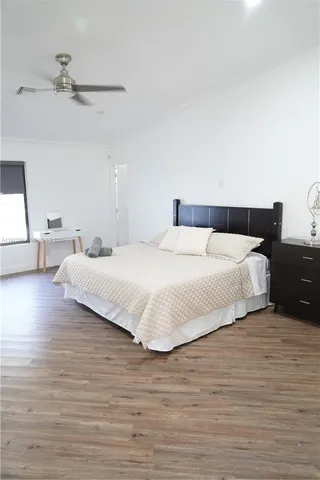 a bedroom with a bed and wooden floor
