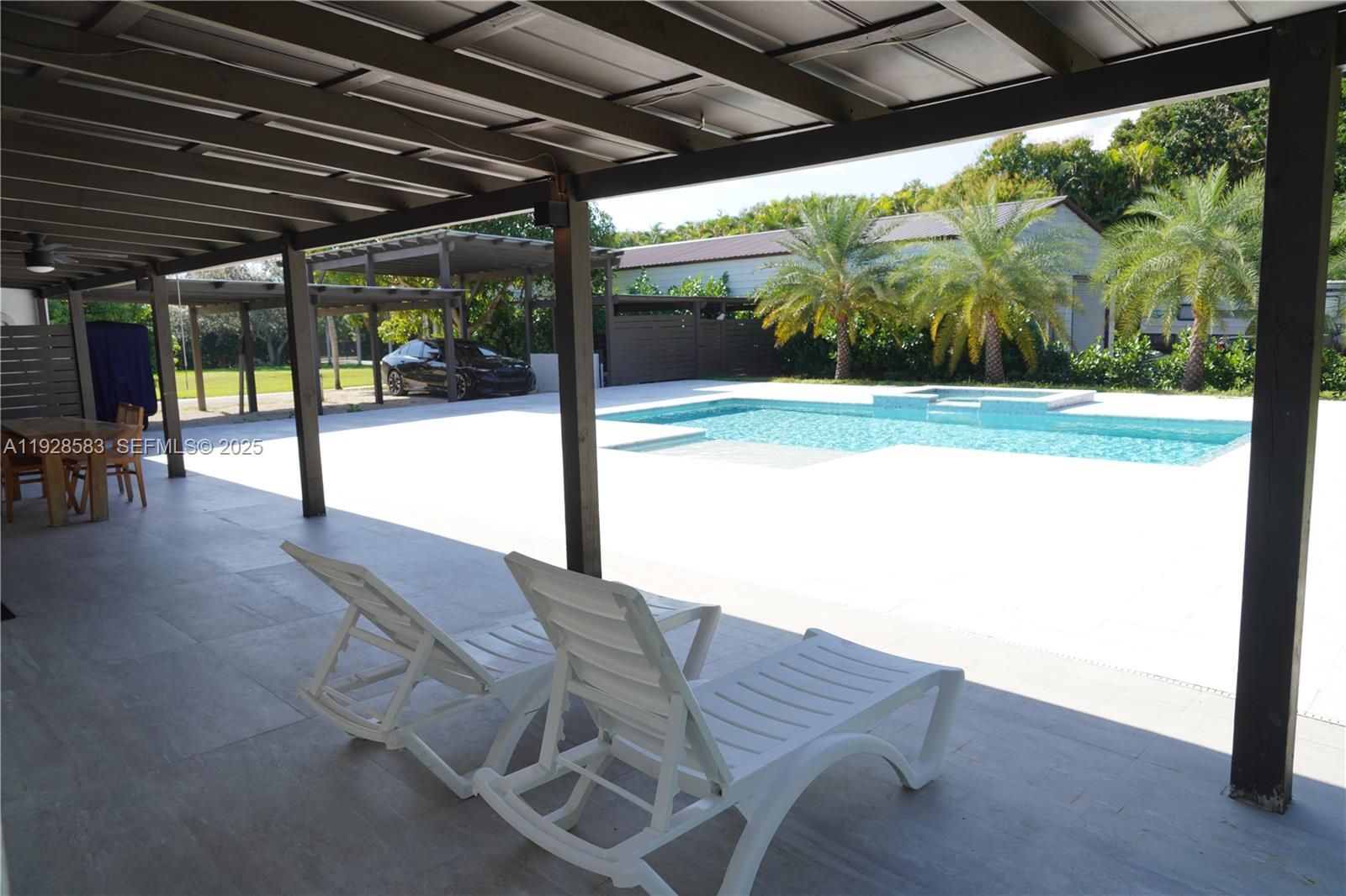 18901 Southwest 50th Street Southwest Ranches, FL 33332 - Photo 37 of 51 a view of a patio with table and chairs under an umbrella with a big yard