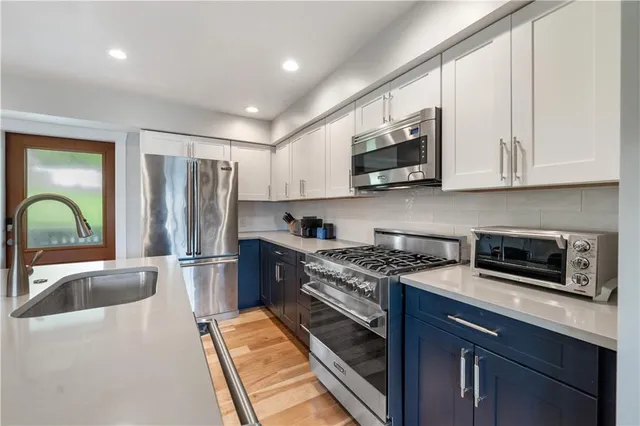 a kitchen with stainless steel appliances granite countertop a stove a sink dishwasher a refrigerator and a microwave