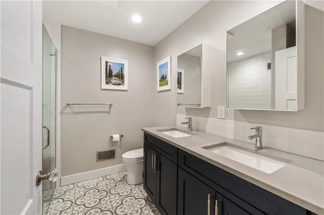 a bathroom with a granite countertop sink a toilet and a mirror