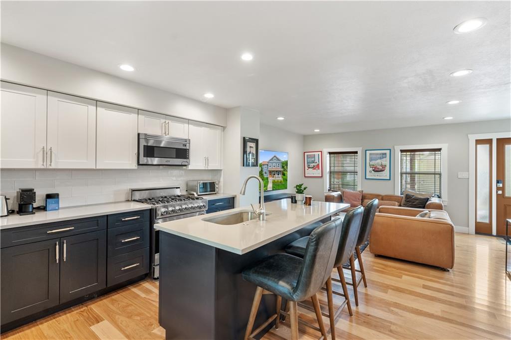 758 5th Street Beaver, PA 15009 - Photo 9 of 38 a kitchen with stainless steel appliances granite countertop a stove top oven a sink dishwasher a dining table and chairs with wooden floor
