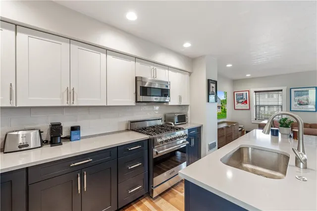 a kitchen with granite countertop a sink dishwasher stove and cabinets