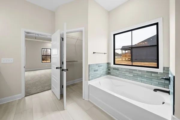 an empty room with a window and a ceiling fan