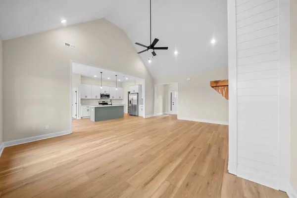an empty room with windows and ceiling fan