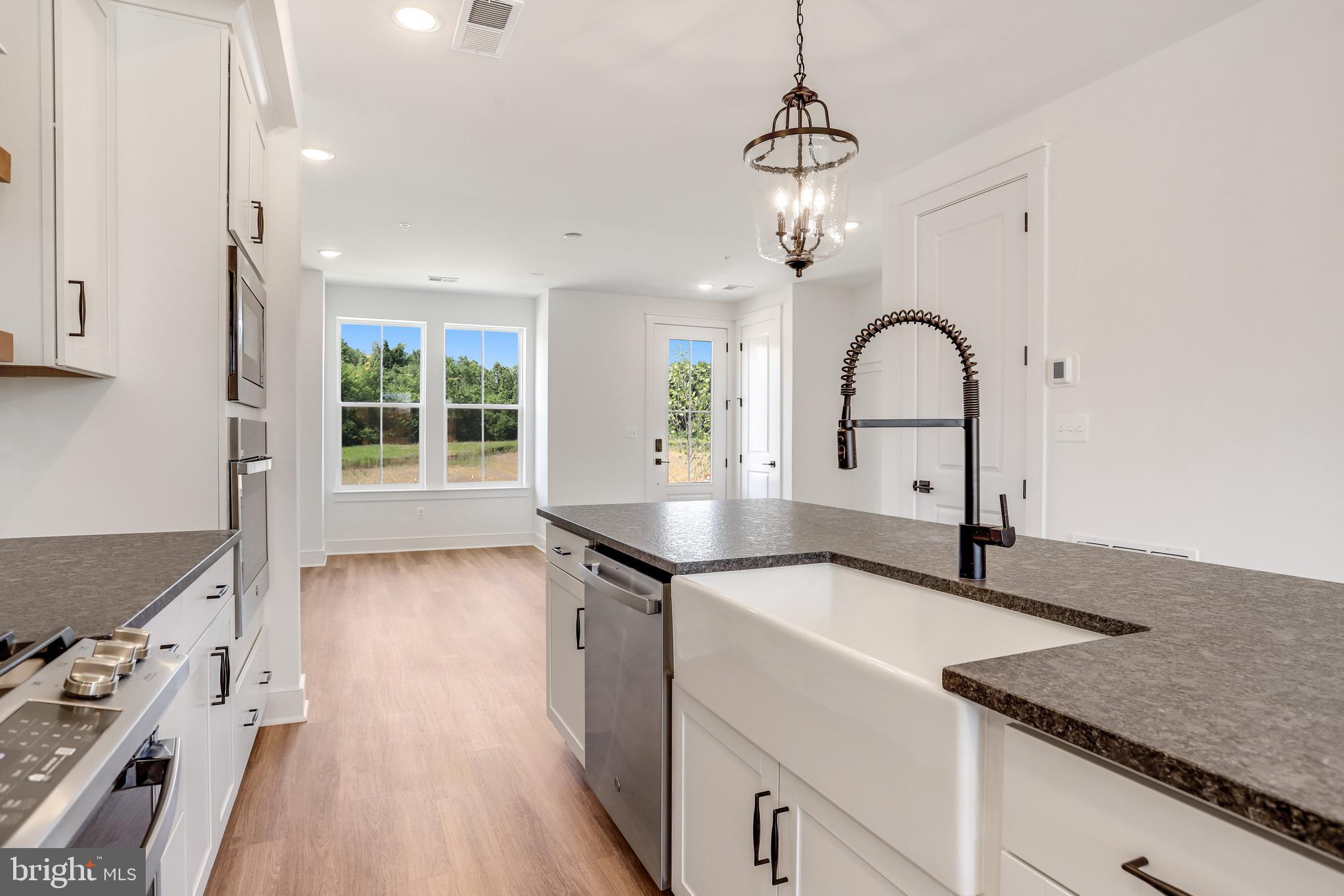 755 Elevation Road Frederick, MD 21702 - Photo 10 of 35 a kitchen with granite countertop a sink stove and cabinets
