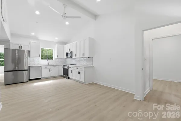 a large kitchen with a stove a refrigerator and a sink