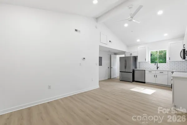 a view of a kitchen with stainless steel appliances a refrigerator and a stove top oven
