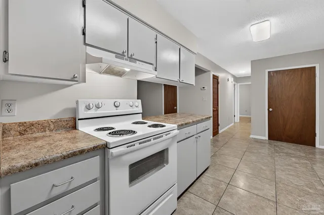 a kitchen with a stove top oven and cabinets