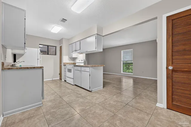 a kitchen with kitchen island granite countertop a stove a sink and a refrigerator