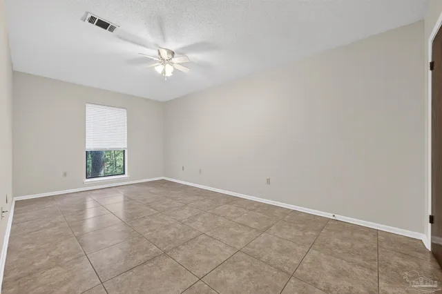 an empty room with windows and fan