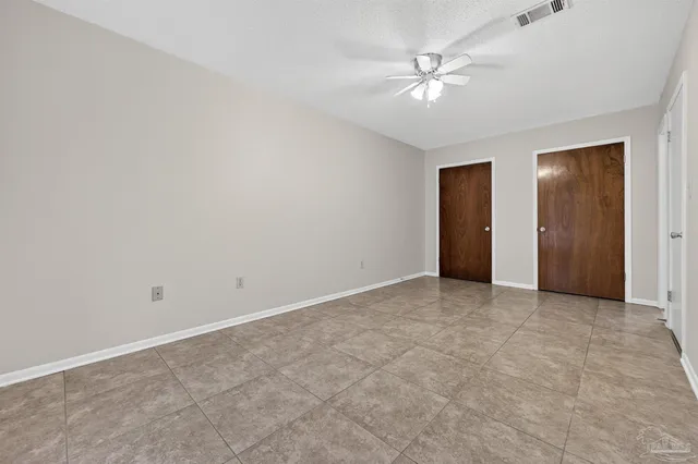 an empty room with closet and a ceiling fan
