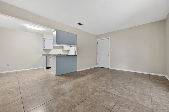 a view of a kitchen with a sink and dishwasher a refrigerator with white cabinets