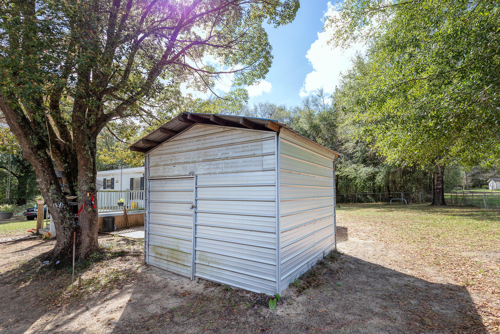 973 Valley Road Crestview, FL 32539 - Photo 15 of 20 a backyard of a house with a large tree and wooden fence