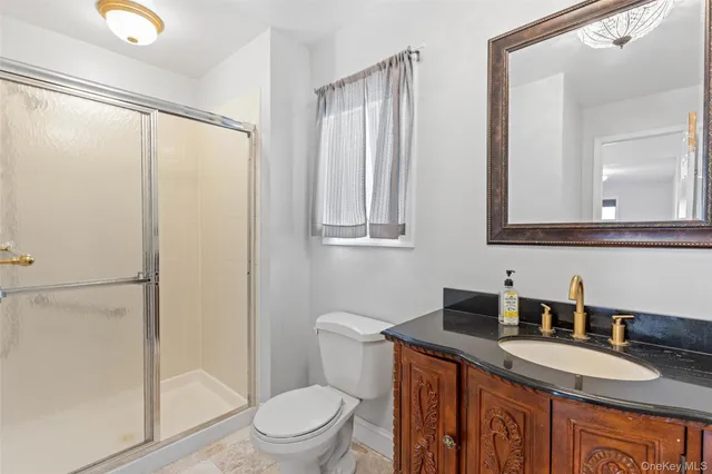 a bathroom with a granite countertop sink mirror vanity and toilet