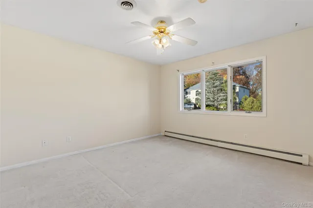an empty room with a window and a ceiling fan