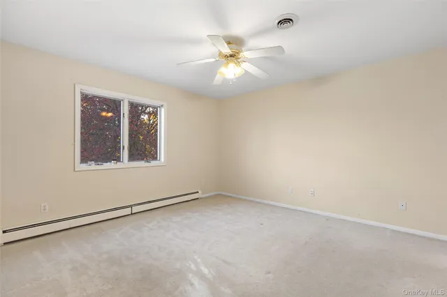 an empty room with a window and a fan