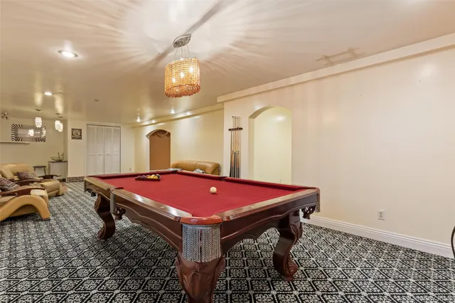 a room with pool table and a chandelier