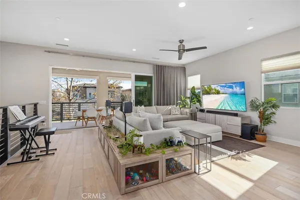 a living room with furniture a flat screen tv and a floor to ceiling window
