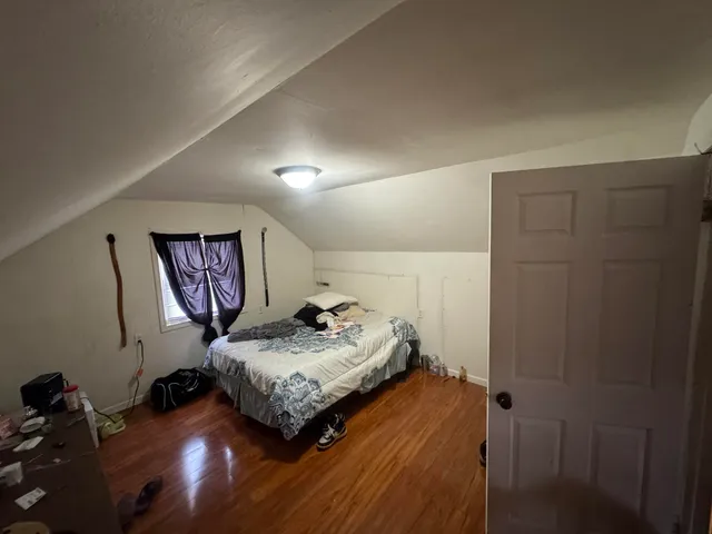 a bedroom with a bed and wooden floor