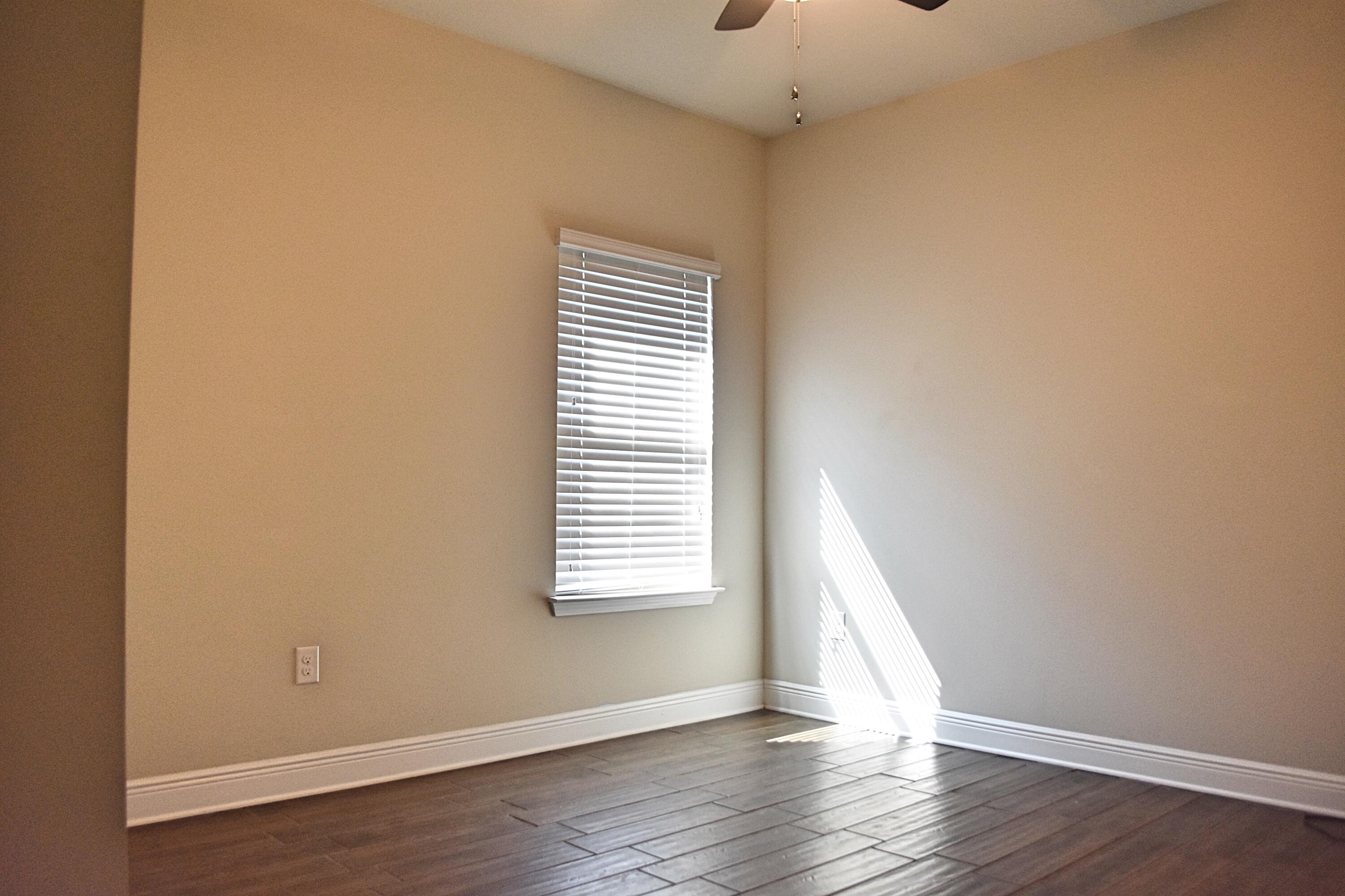 41 Twain Trail Freeport, FL 32439 - Photo 22 of 24 an empty room with wooden floor and windows