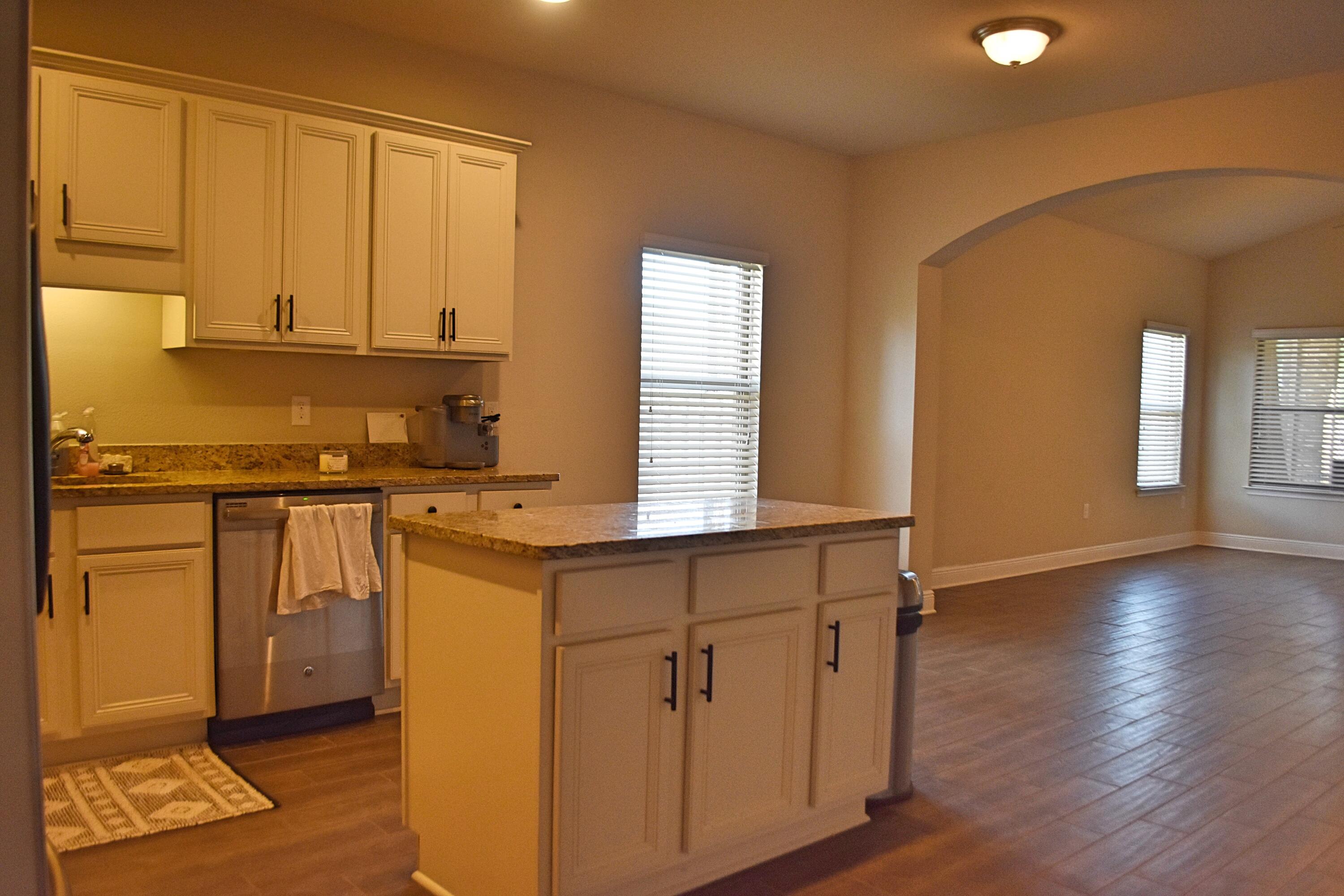 41 Twain Trail Freeport, FL 32439 - Photo 9 of 24 a kitchen with stainless steel appliances granite countertop a stove a sink and a refrigerator with wooden floors