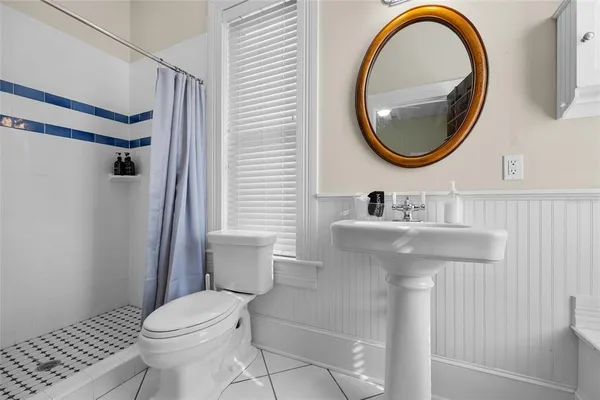 a bathroom with a granite countertop toilet sink and mirror