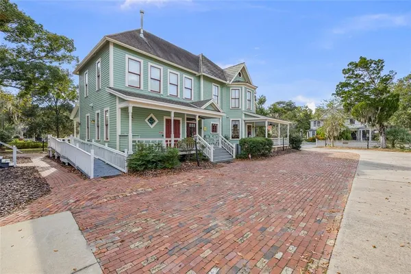 a front view of a house with a garden and tree