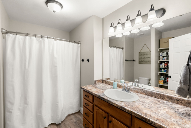 2485 South 1100th Street West Logan, UT 84321 - Photo 20 of 53 Bathroom featuring a single vanity with wood-finish cabinetry, a white basin, and a speckled countertop