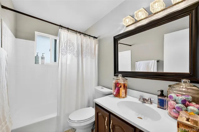 a bathroom with a sink vanity mirror and toilet