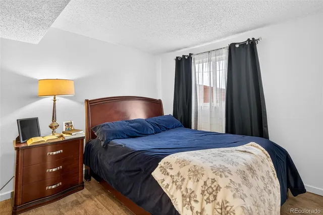 a bedroom with a bed and a lamp on dresser