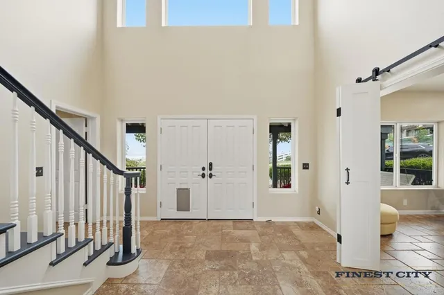 a large white kitchen with a large window and stainless steel appliances