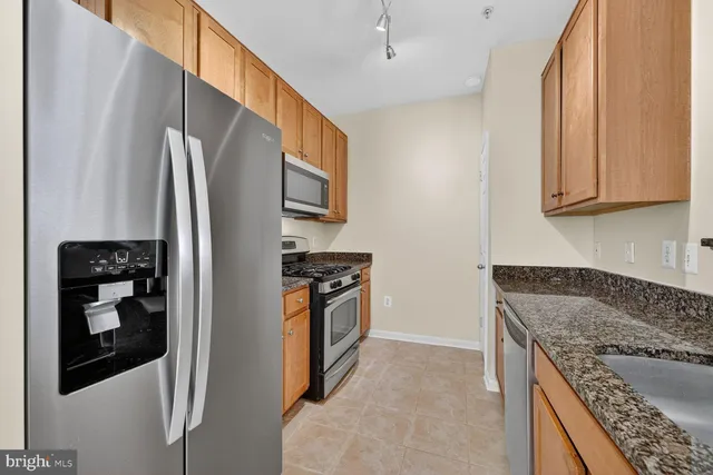 a kitchen with stainless steel appliances granite countertop a refrigerator and a stove