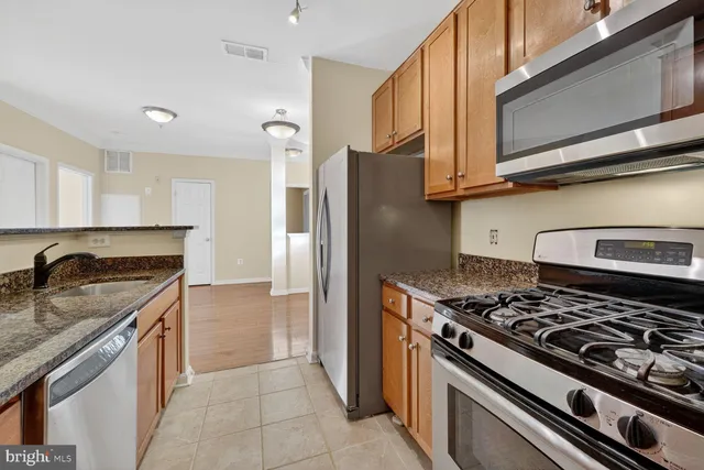 a kitchen with stainless steel appliances granite countertop a stove and a refrigerator
