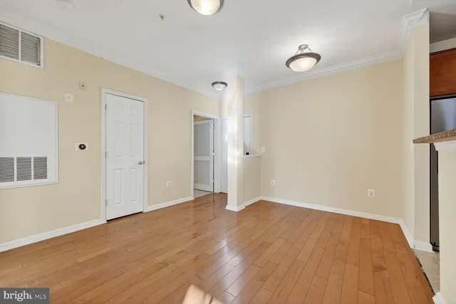 a view of an empty room with wooden floor
