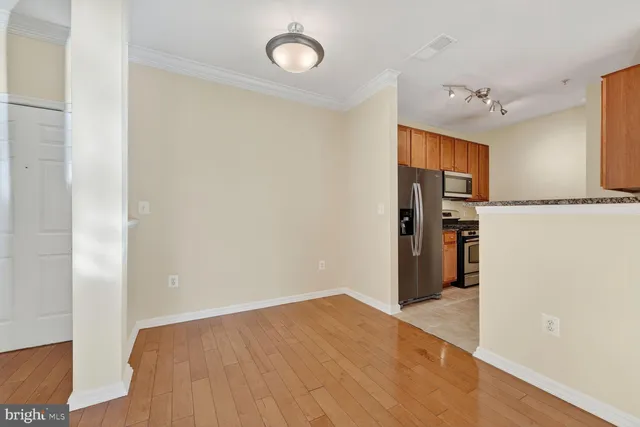 a view of a kitchen with refrigerator and wooden floor