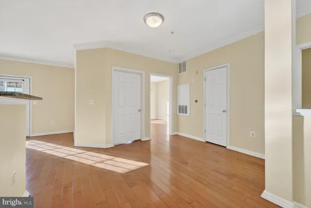 a view of an empty room with wooden floor
