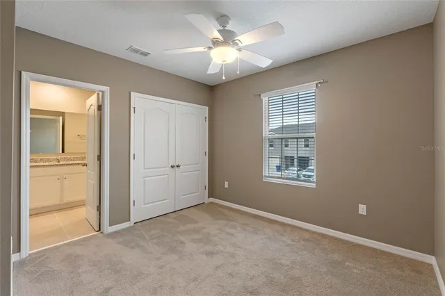 an empty room with closet and windows