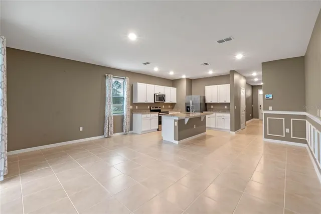 a large white kitchen with a large window and kitchen view