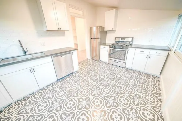 a large white kitchen with a large window