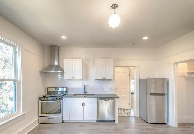 a kitchen with a sink stainless steel appliances and window