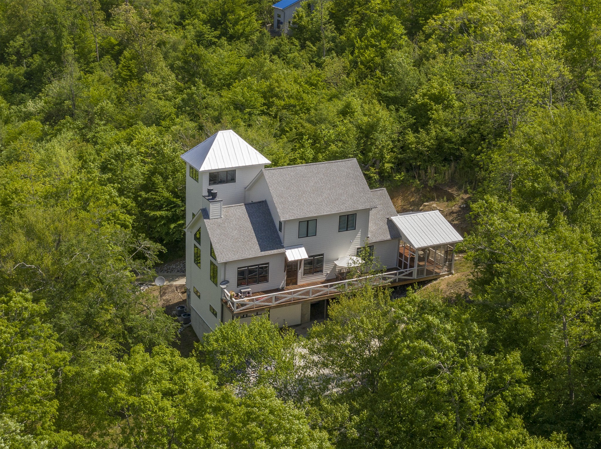 an aerial view of a house with swimming pool and wooden fence