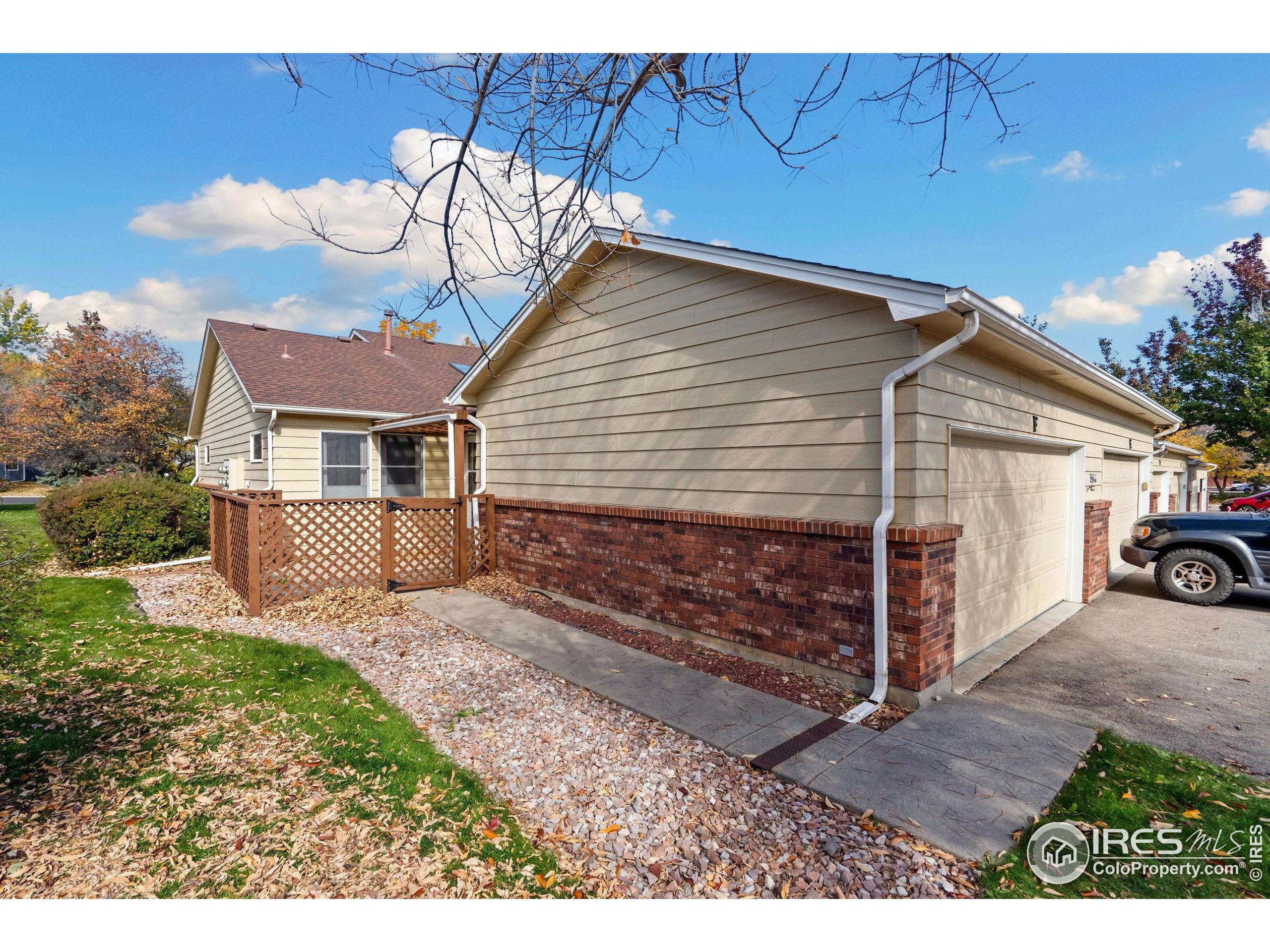 3344 Hickok Drive, Unit F Fort Collins, CO 80526 - Photo 22 of 24 a view of a house with a bed and wooden fence