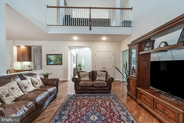 a view of a dining room and livingroom with furniture wooden floor a chandelier
